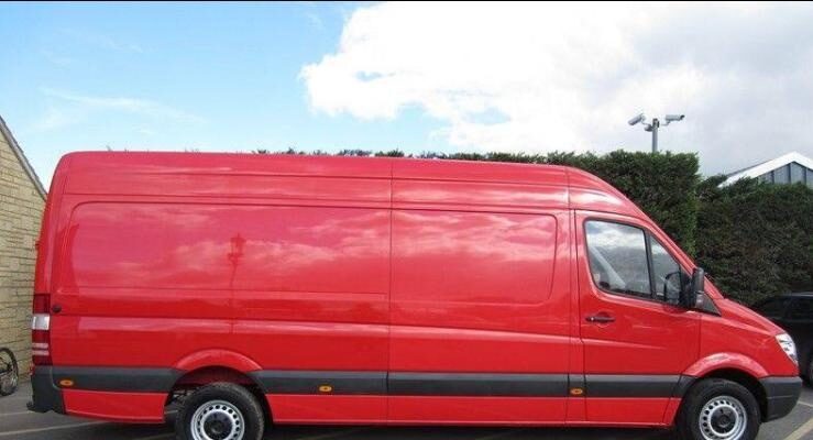 Large red Man and Van Guildford removals van parked outside, ready for transport and moving services.